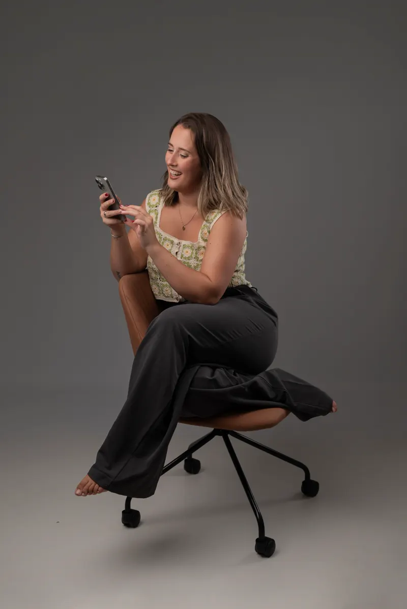 Camila Aldabalde, fotógrafa, sonriendo mientras mira su celular